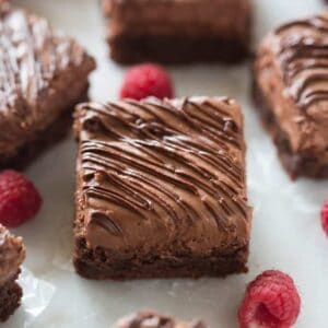 Raspberry Truffle Brownies are decadent and completely heavenly! A fudgy chocolate brownie with whipped raspberry truffle frosting and melted chocolate drizzled on top. | tastesbetterfromscratch.com