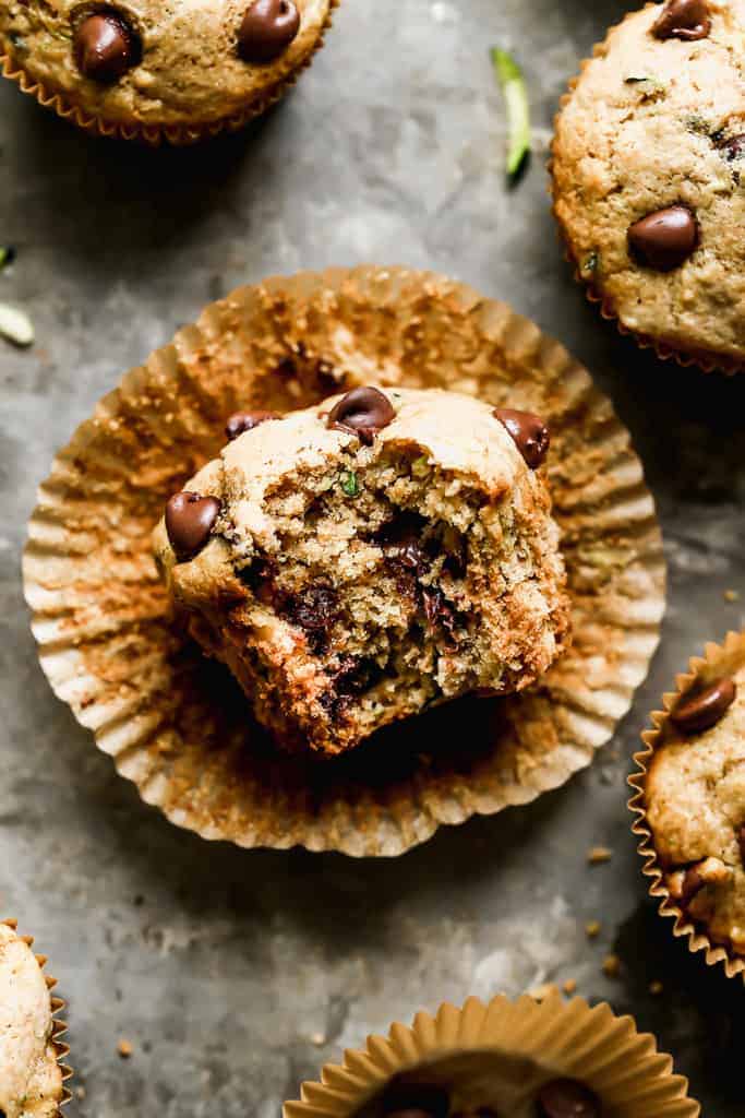 A chocolate chip zucchini muffin with a big bite take out of the center.