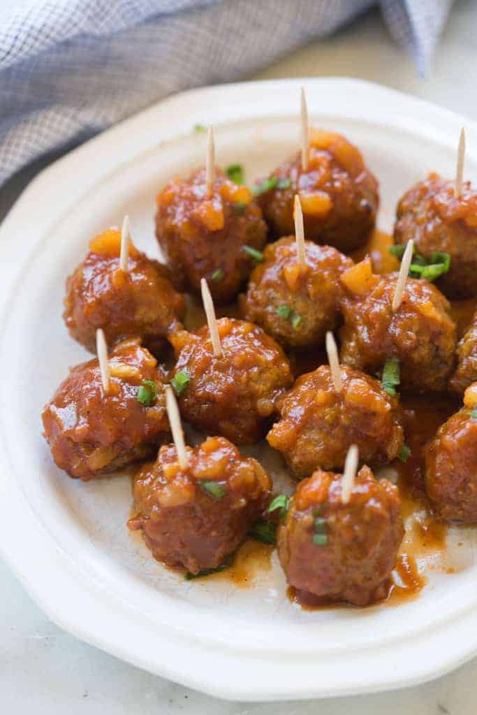 Hawaiian BBQ Meatballs on a plate with a toothpick in each one.