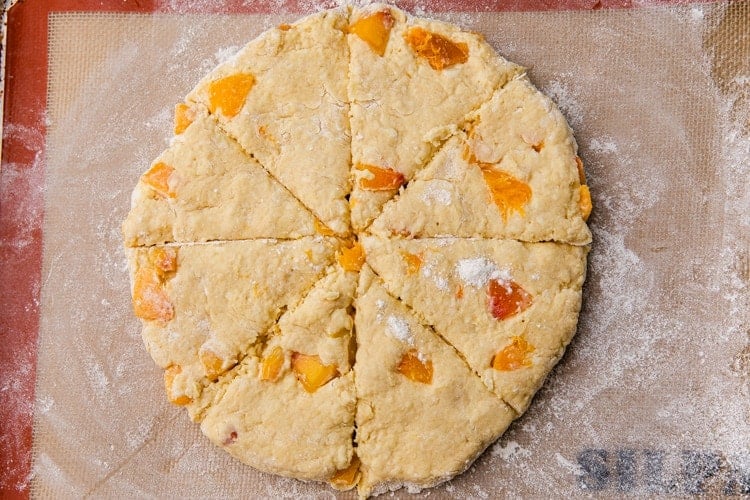 Scones dough shaped into a circle and cut into eight triangles.