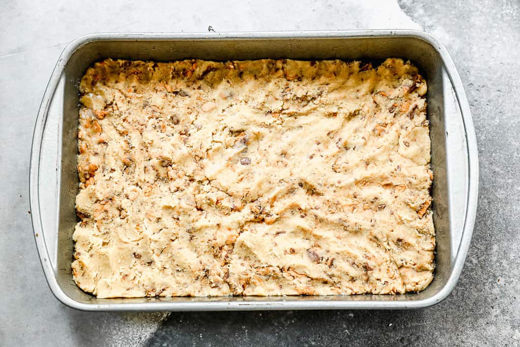 Butterfinger Bars dough spread into a 9x13 baking pan and ready to bake.