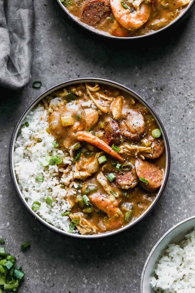 Gumbo with sausage and shrimp in a bowl with white rice.