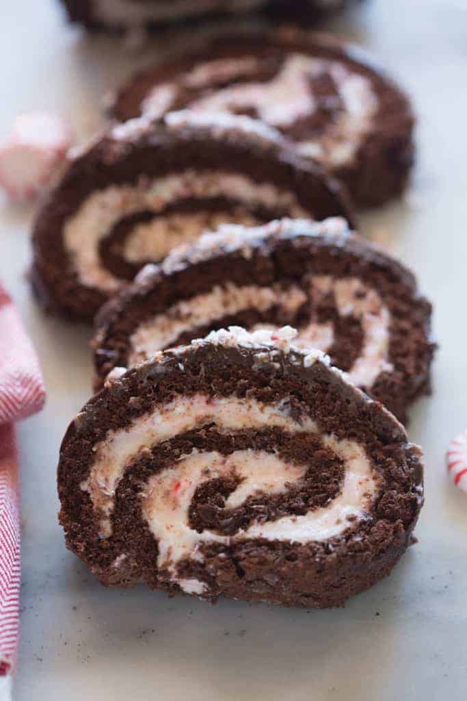 The inside swirl of four slices of chocolate peppermint cake roll laying offset against each other.