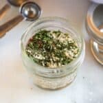 A small mason jar filled with dry spices to make Homemade Dry Onion Soup Mix