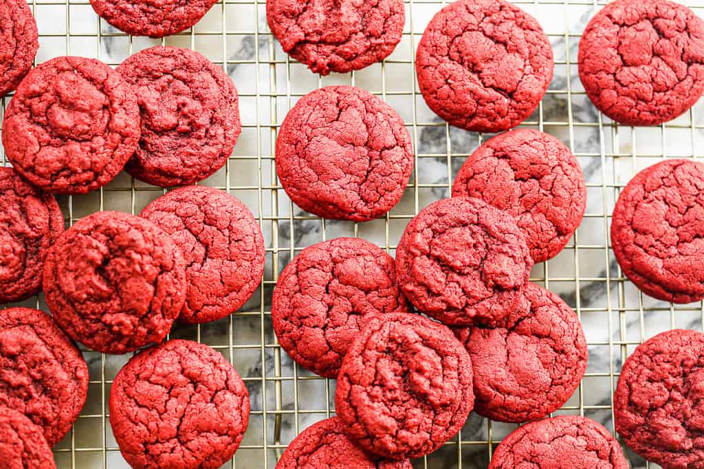 Baked red velvet cookies on a cooling rack.