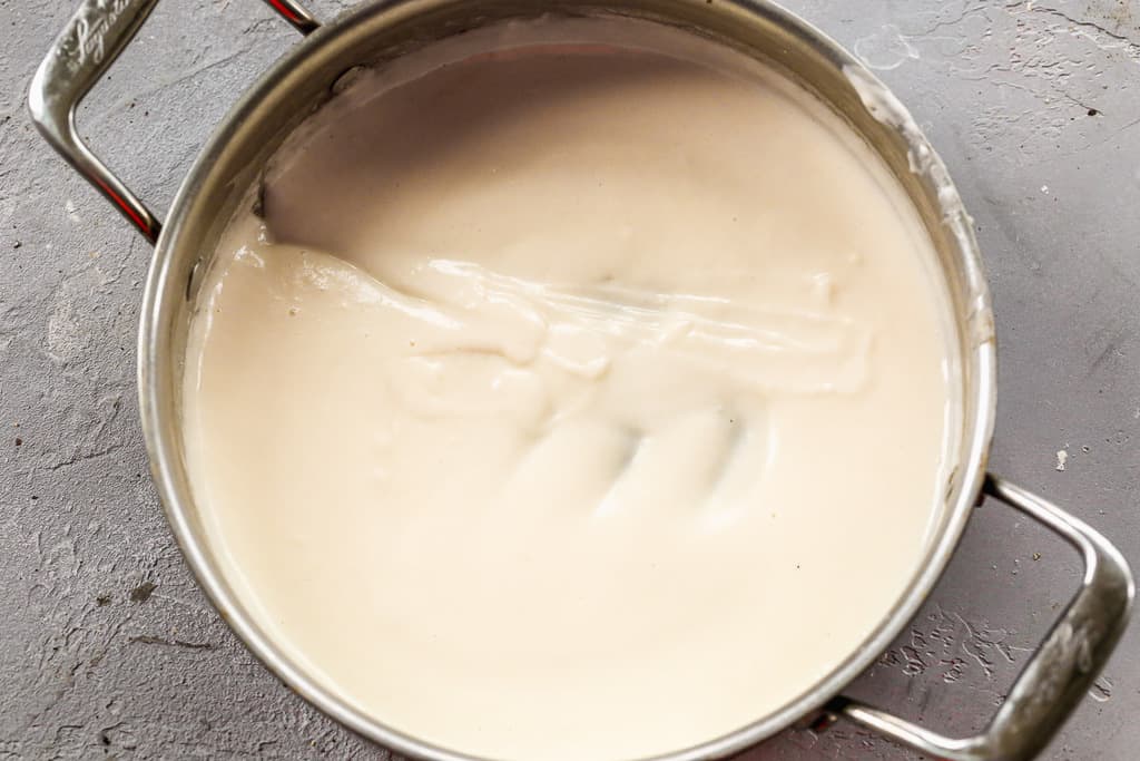 Creamy white roux sauce cooking in a skillet.