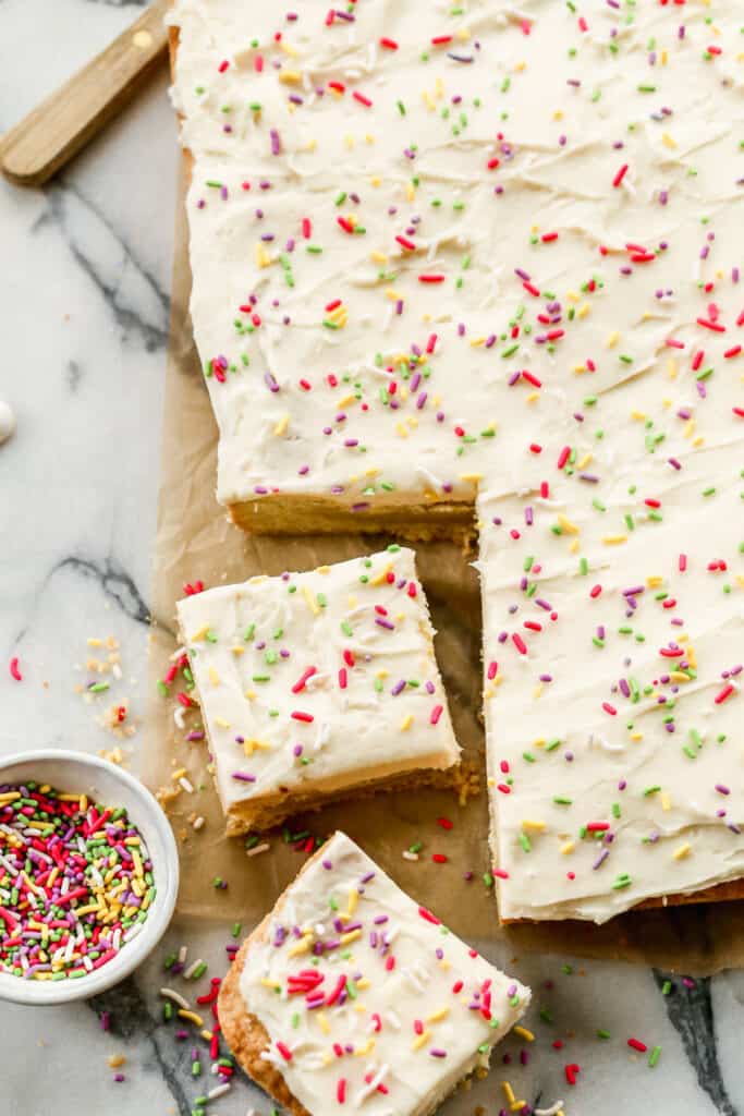 Frosted sugar cookie bars with sprinkles on top.