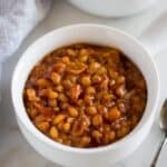Instant Pot Baked Beans served in a white bowl with a handle, and another filled bowl in the background.