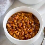 Instant Pot Baked Beans served in a white bowl with a handle, and another filled bowl in the background.