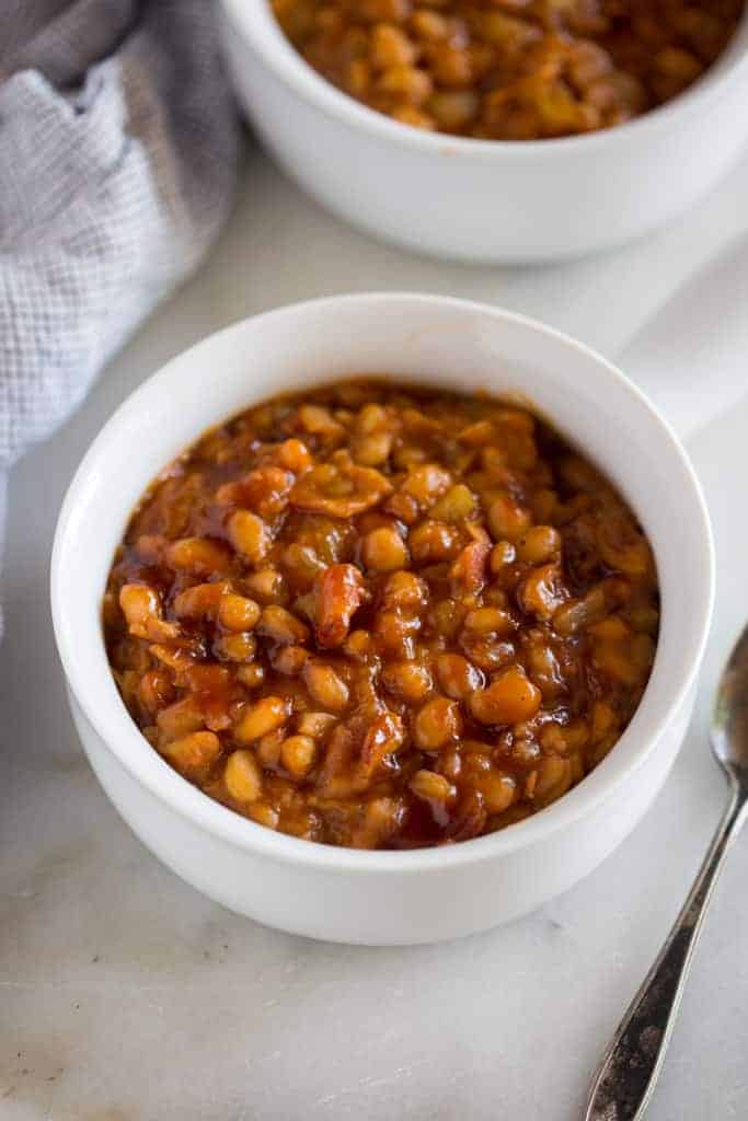 Instant Pot Baked Beans served in a white bowl with a handle, and another filled bowl in the background.