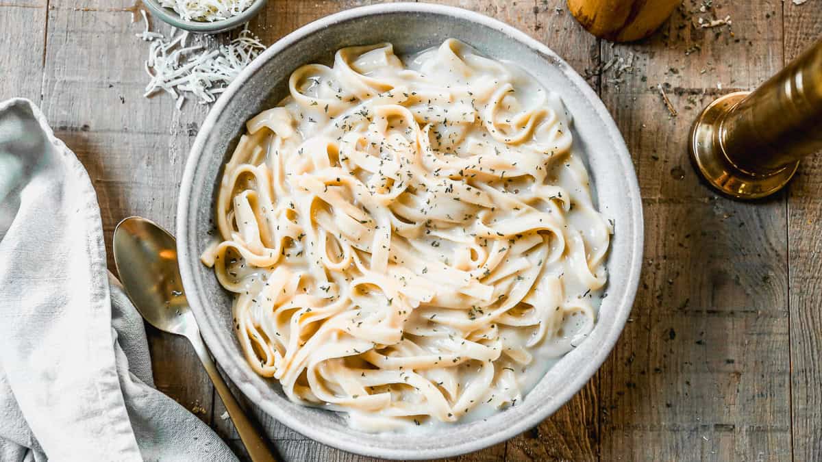 This Instant Pot Fettuccine Alfredo recipe is creamy, comforting, and half of the calories! It's a true dump it and forget it instant pot recipe that allows you to have dinner on the table in just 30 minutes!