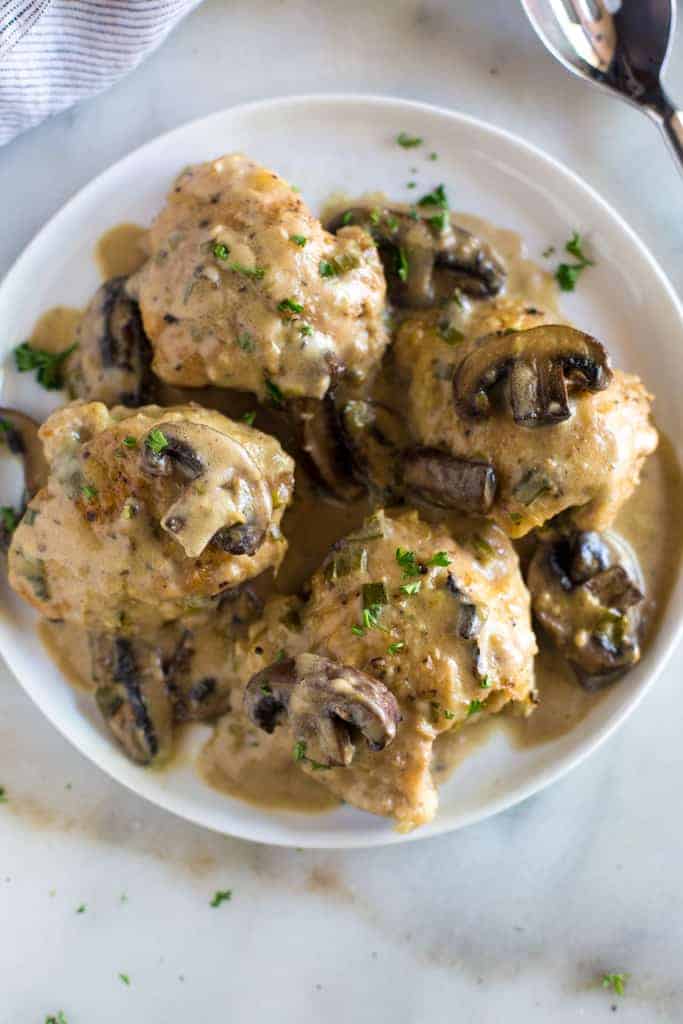 Overhead photo of a white plate with chicken marsala on it, which includes chicken covered in a creamy marsala wine sauce with mushrooms.