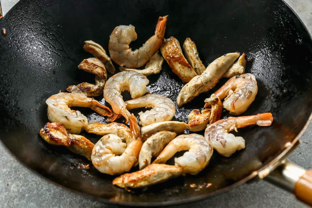 Shrimp and chicken sautéing in a pot.