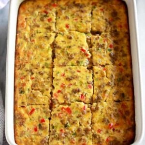 Breakfast casserole baked in a 9x13'' white pan and cut into twelve servings.