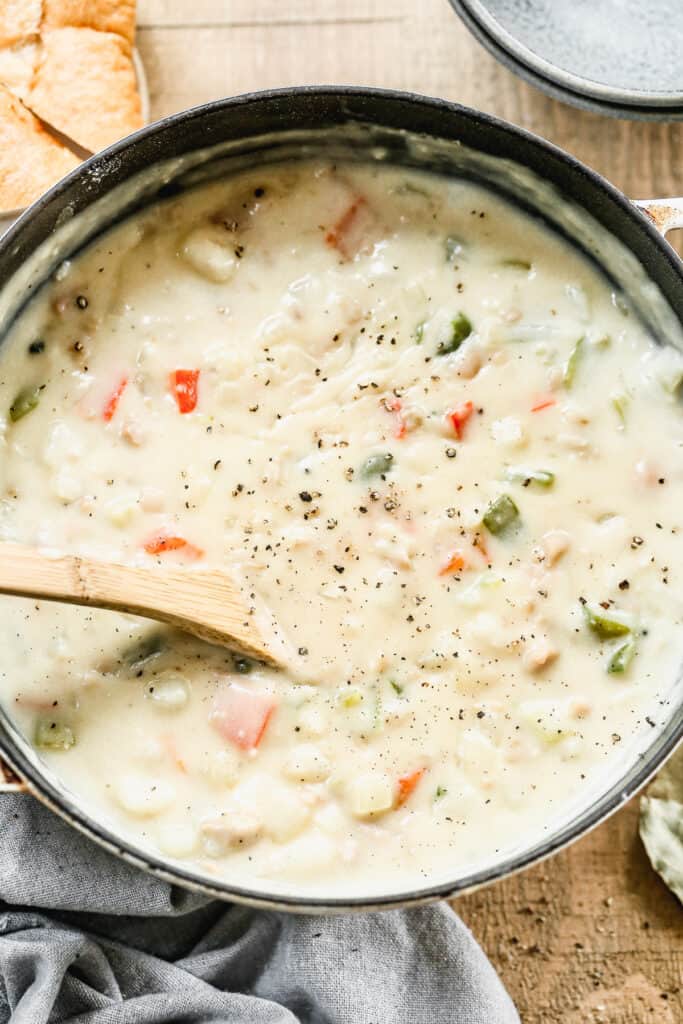 A large soup pot with clam chowder cooking in it.