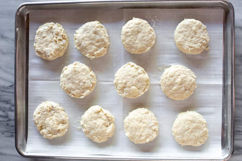 Uncooked biscuits placed on a baking sheet, ready to bake.