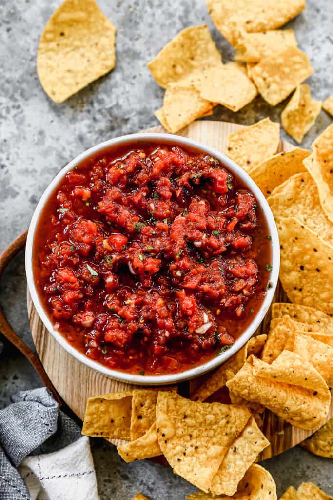 Fresh homemade salsa served in a bowl, with tortilla chips on the side.