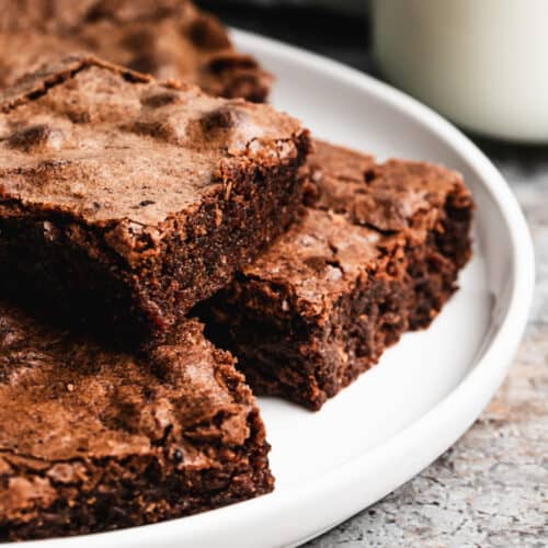 An easy Fudgy Brownie recipe stacked on a plate, ready to serve.