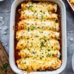 A pan filled with Chicken and Rice Enchiladas baked until the cheese is melted and chopped cilantro sprinkled on top.