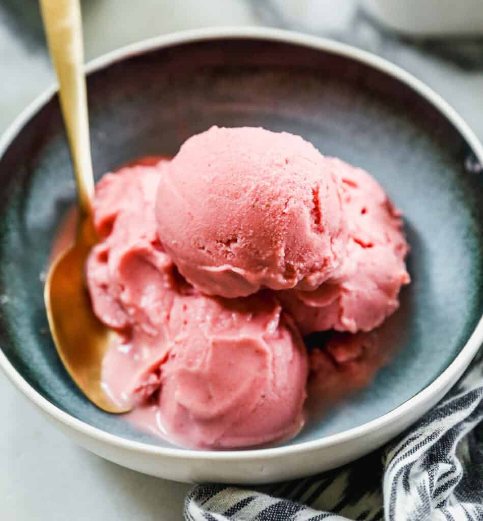 A homemade Frozen Yogurt recipe made with fresh strawberries, scooped and served in a bowl.