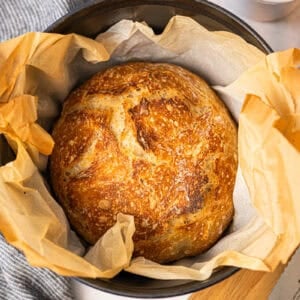 This no knead Artisan Bread recipe only requires 4 pantry staples and takes 5 minutes of prep to get a beautiful golden, crusty loaf of bread with a soft interior.