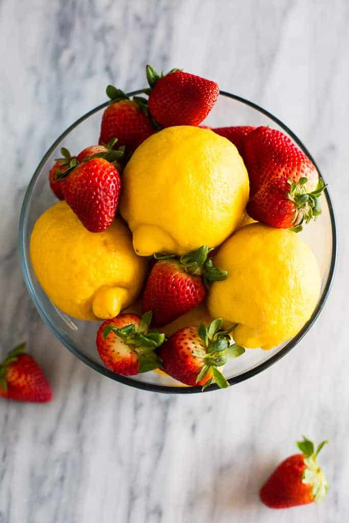 Overhead photo of a bowl of lemons and strawberries.