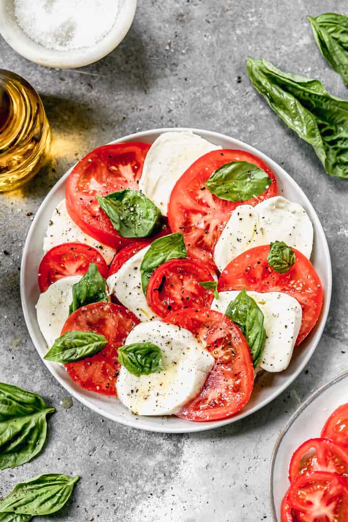 Caprese Salad made with fresh mozzarella and tomato slices, served on a plate.