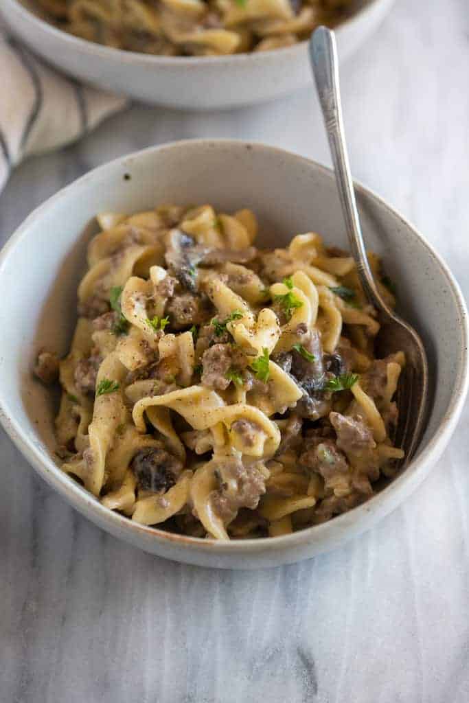 A bowl with instant pot stroganoff made with egg noodles, ground beef and mushrooms.