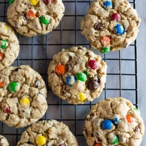 Monster cookies with m&m's on a wire cooling rack.