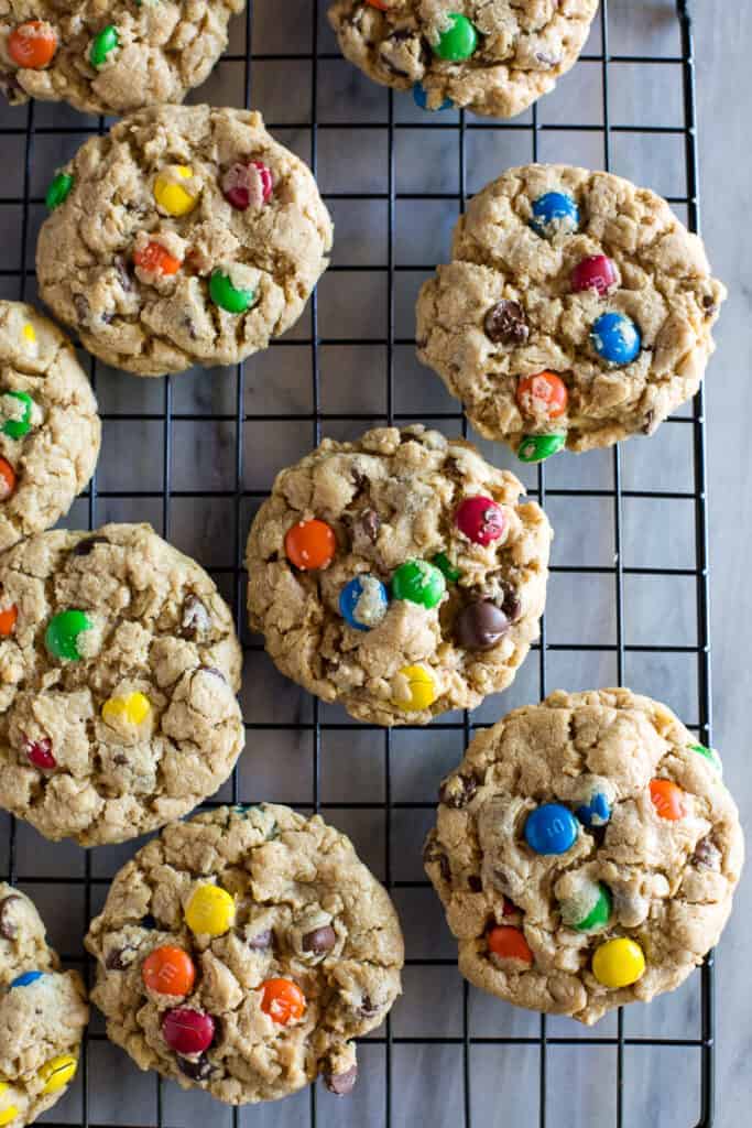 Monster cookies with m&m's on a wire cooling rack.