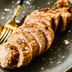 A pork tenderloin marinade grilled then sliced on a serving tray after using the best pork tenderloin marinade.
