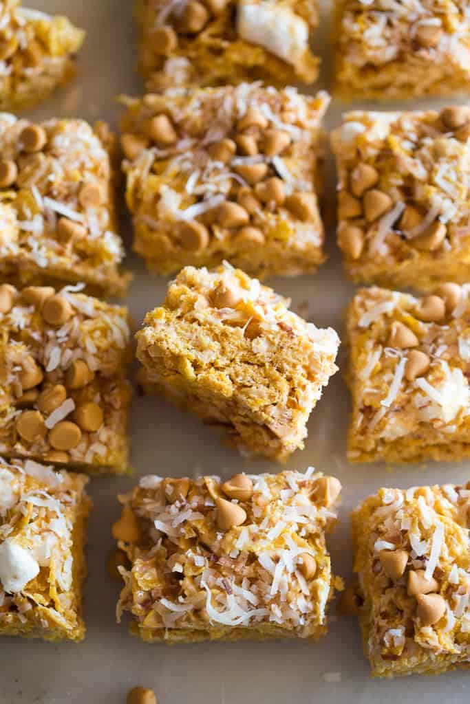 Butterscotch cereal bar squares in a line with one tipped on its side.