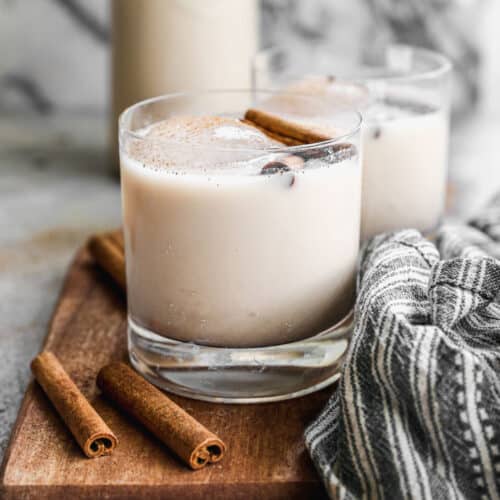 Horchata in a glass of ice topped with a cinnamon stick.
