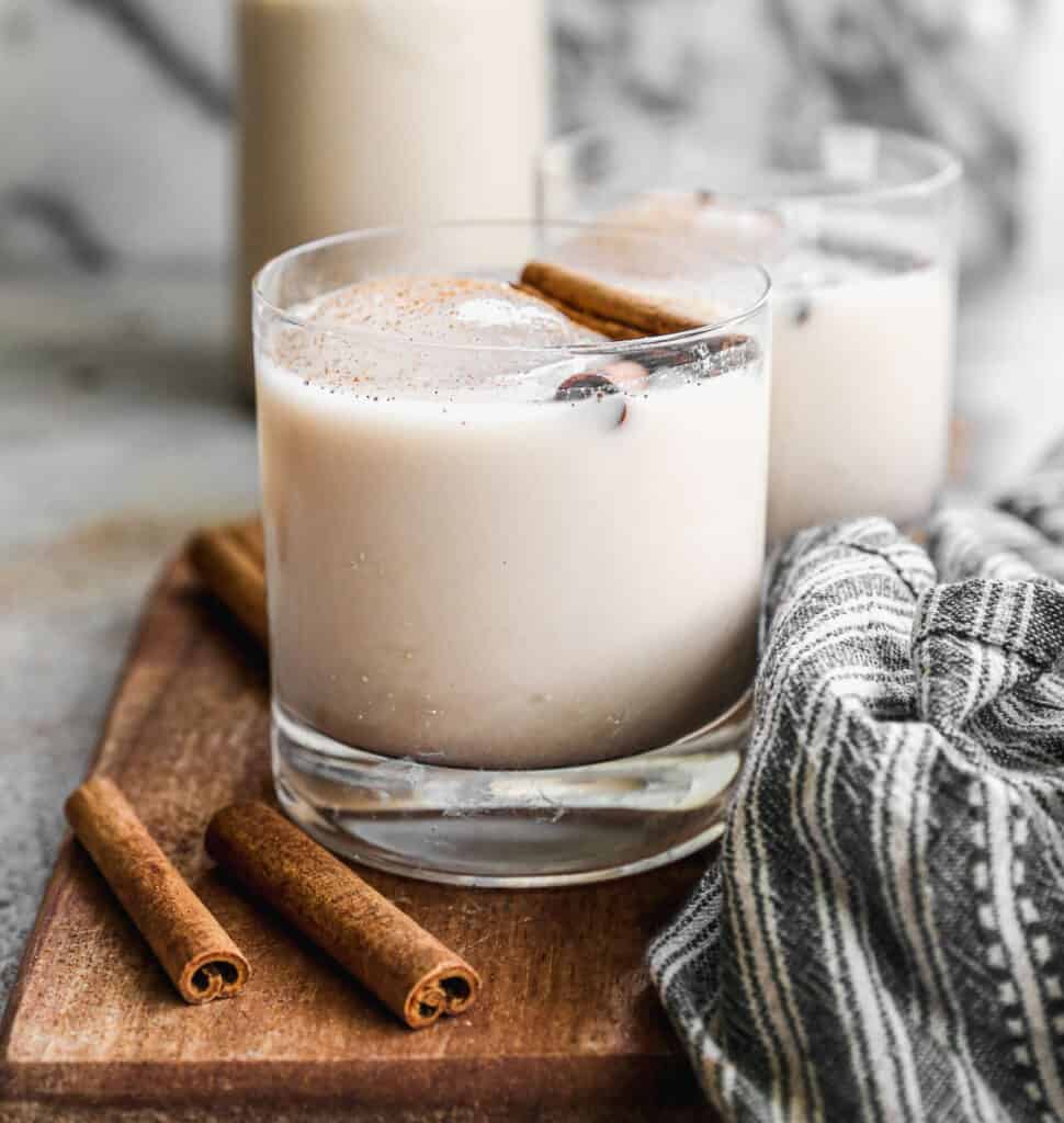 Horchata in a glass of ice topped with a cinnamon stick.