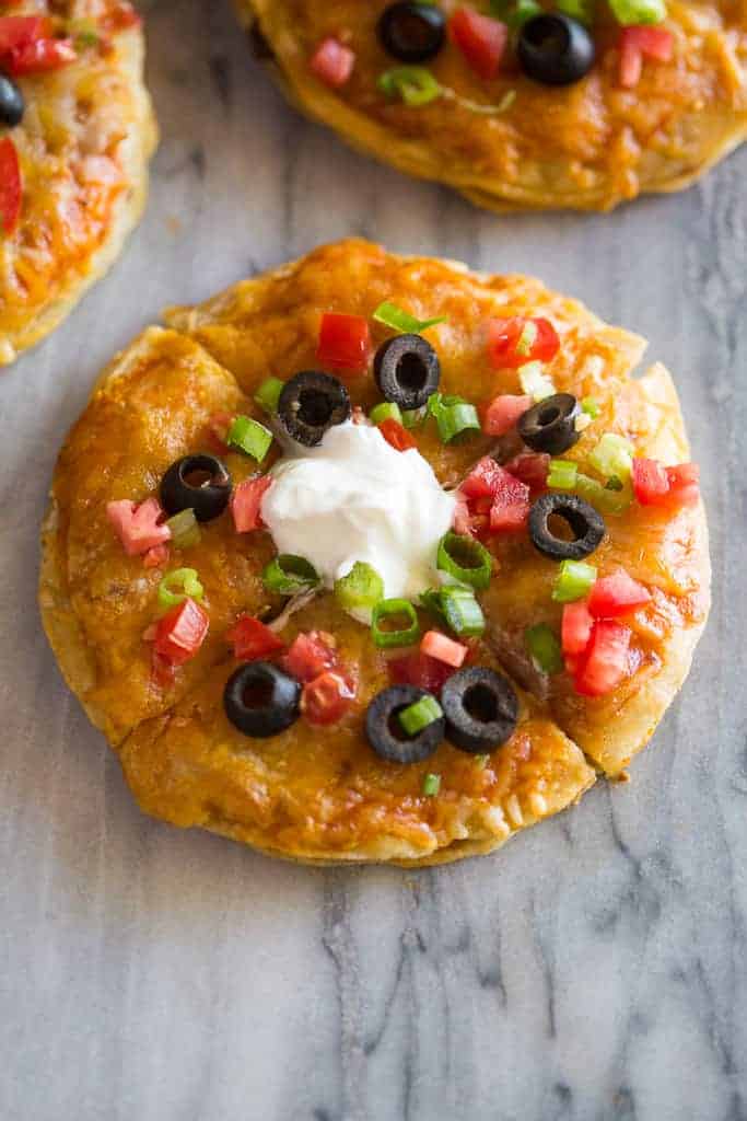 Mexican Pizza made with two corn tortillas with cheese, tomato, olives and sour cream.