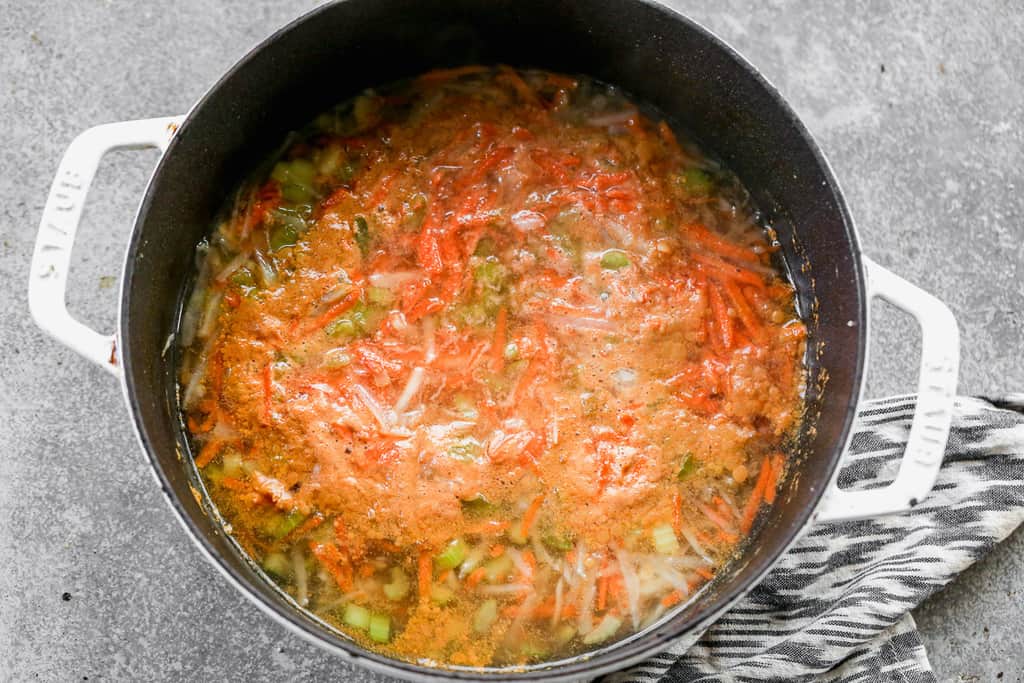 Chopped and shredded vegetable cooking in a soup pot with broth.