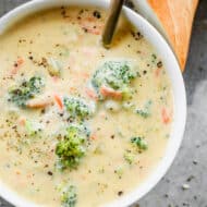 Broccoli cheese soup served in a bowl with a spoon.