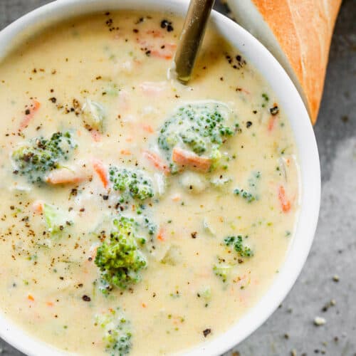Broccoli cheese soup served in a bowl with a spoon.