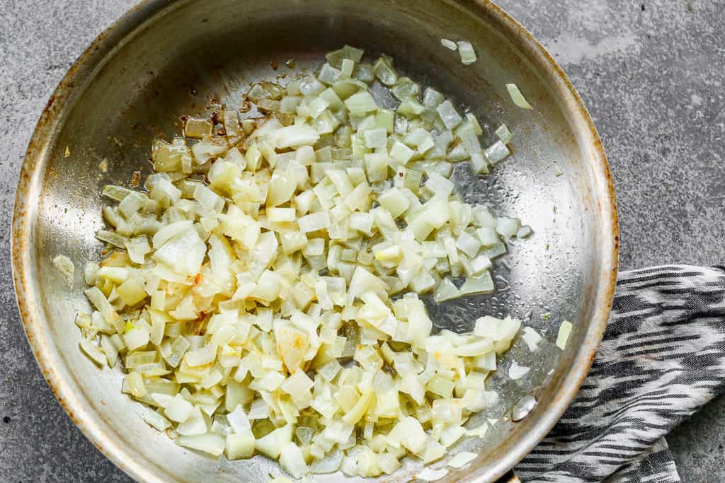 Chopped onion sautéing in a skillet.