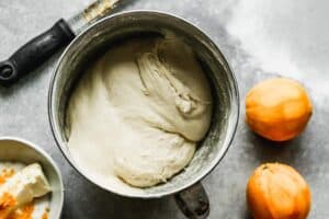 A mixing bowl with dough for orange rolls.