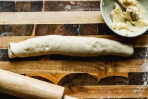 A long log of rolled up dough for orange rolls.
