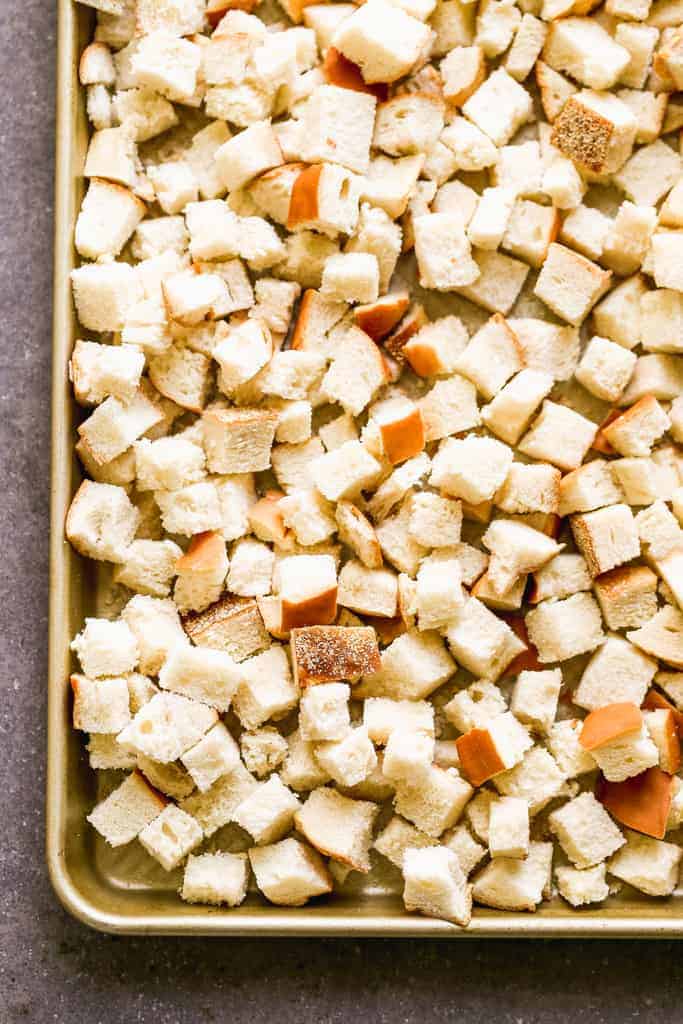 Dried bread cubes on a baking sheet.