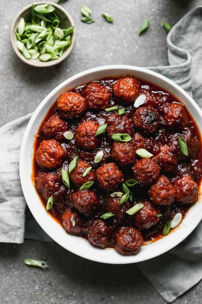 BBQ Meatballs appetizer served in a bowl garnished with green onion.