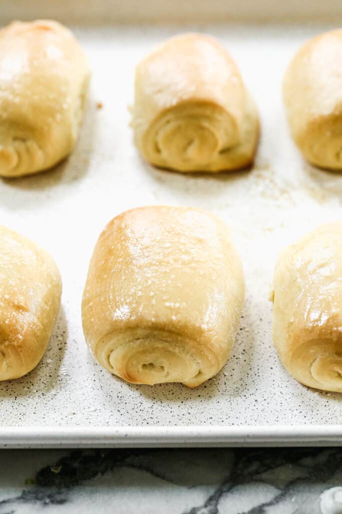Freshly baked rolls on a sheet pan.
