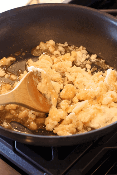 Sugar being melted in a skillet on the stove.