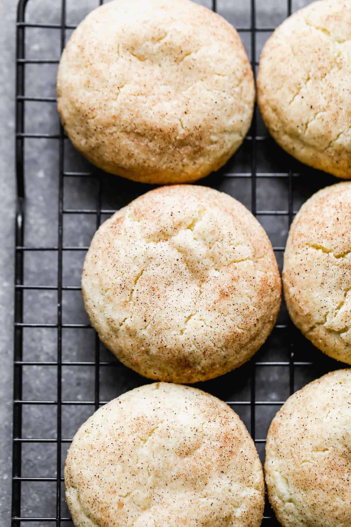 The best Snickerdoodle recipe cooling on a black cooling rack. Soft, chewy, and ready to be eaten. 