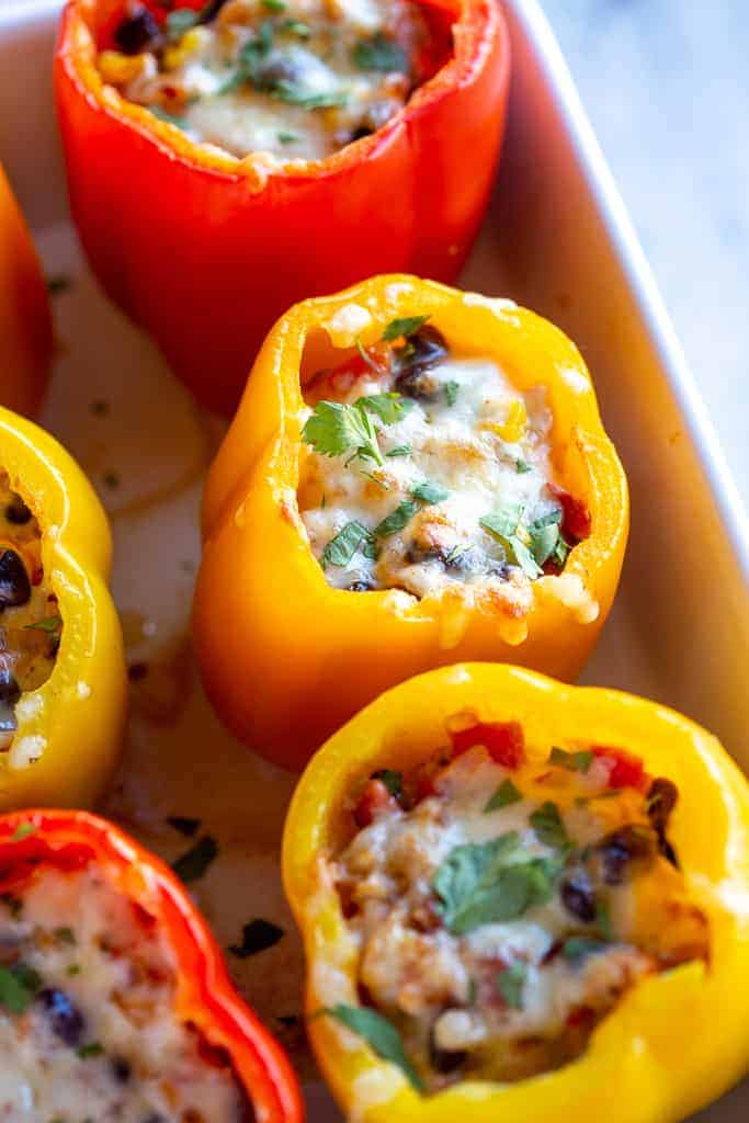 Close up of a stuffed pepper in a casserole dish with other stuffed peppers.