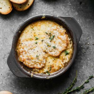 A bowl of French onion soup with crusty bread and melted cheese on top.