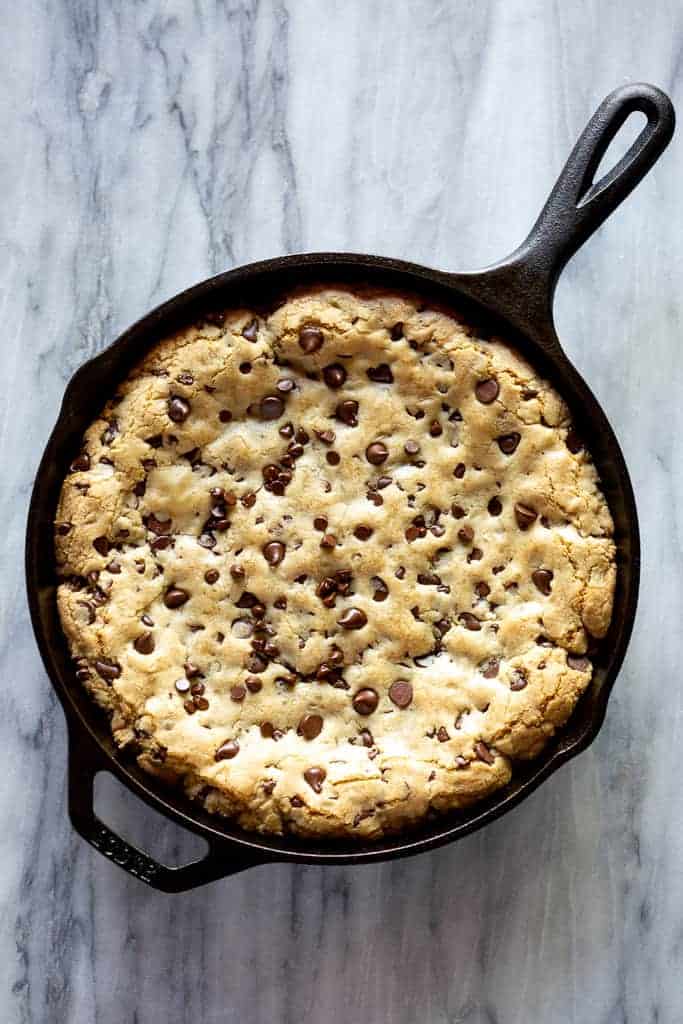 Overhead photo of a chocolate chip skillet cookie baked in a cast iron pan.