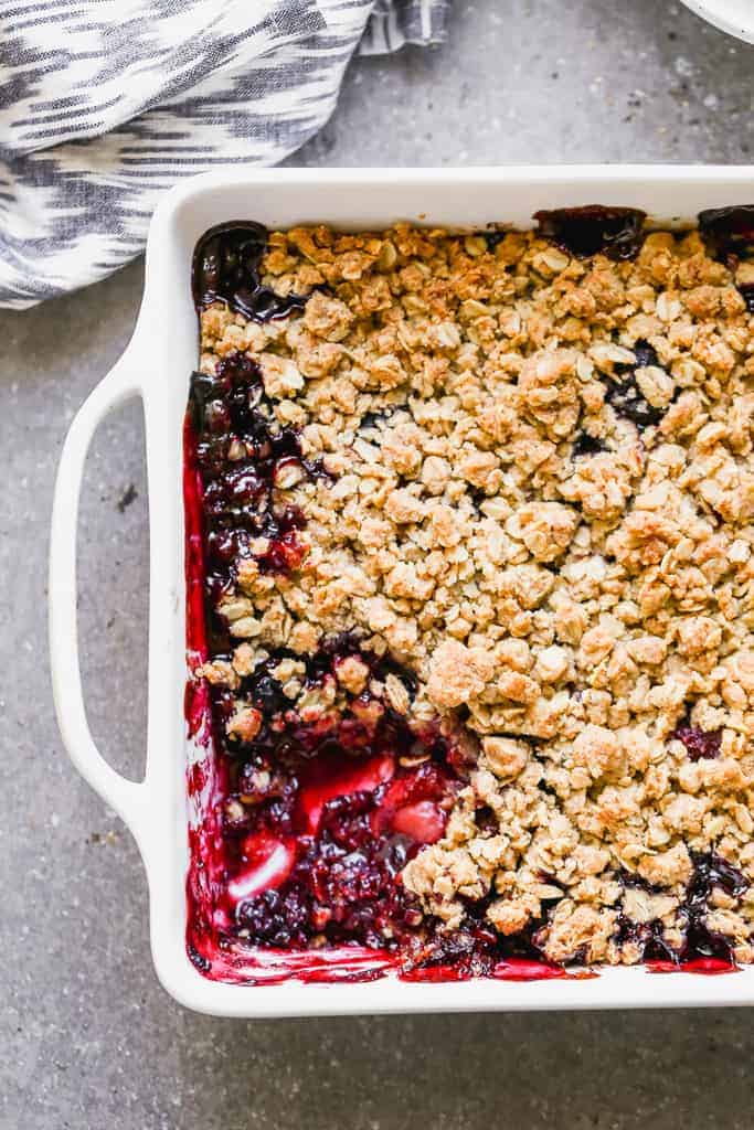 Berry crisp with crumble topping baked in a white dish.